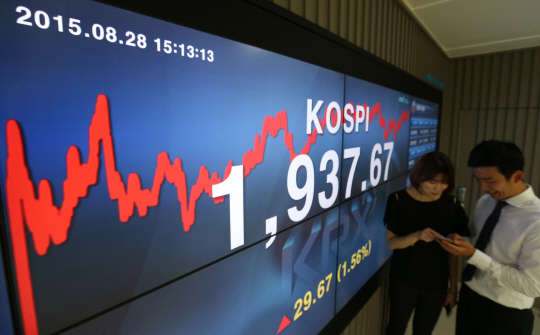 28일 오후 서울 여의도 한국거래소 홍보관에서 직원이 코스피 지수가 나타난 전광판 앞에서 휴대전화를 바라보고 있다.       이날 세계 금융 시장이 점차 안정을 되찾으며 코스피 지수는 전거래일보다 29.67포인트(1.56%) 오른 1,937.67을 기록하며 1,930선을 회복했다.